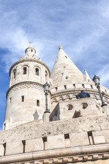 Fototapeta na wymiar Fishermans Bastion in Budapest, Hungary. Major tourist attraction of the Hungarian capital city. Fairy tale monument, built in Neo-Romanesque style. Photographed from below, blue sky. Vertical photo