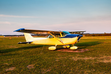 Fototapeta na wymiar Small private airplane on the airfield in the evening light