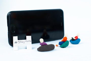 Close up on Plasticine family watching tv. Stick man family using screen for enjoing video at home. Stay home concept during quarantine. Hobby saves lives.