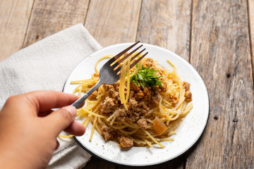 Spaghetti bolognese with parmesan cheese on wooden background