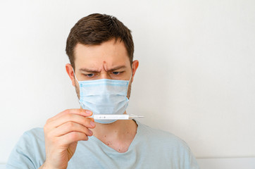 Coronavirus. Quarantine. A man measures the temperature. Heat. In the mask.