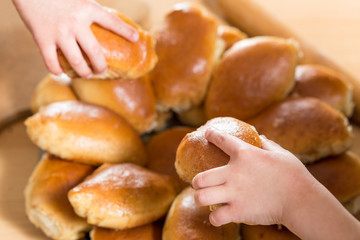 Children take home buns from a plate