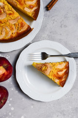 Piece of apple pie on a white plate food flat lay. homemade pie recipe. home food delivery during coronavirus COVID-19. on a concrete background top view