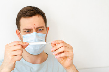 Coronavirus. Quarantine. A man measures the temperature. Heat. In the mask.