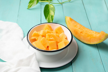 Cantaloupe melon in bowl on turquoise background