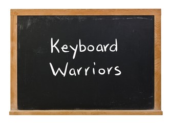 Fototapeta premium Keyboard warriors written in white chalk on a black chalkboard isolated on white