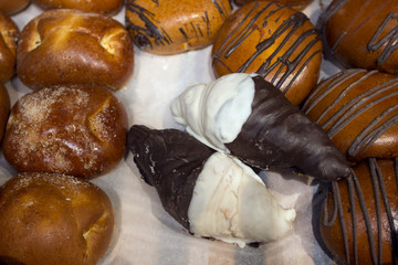 buns with cottage cheese, bagels buns croissants in white sugar glaze, as well as chocolate glaze, pastries on the counter of the bakery