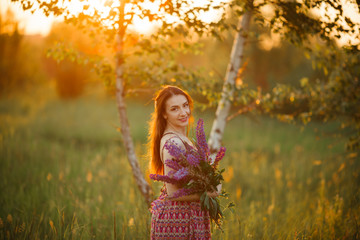 girl in a colored dress. Holds flowers in her hands