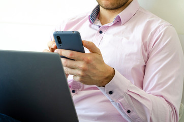 Coronavirus. Quarantine. A man in a shirt and jeans solves work issues remotely.