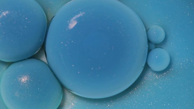 Fluid art painting video, abstract acryl texture with colorful bubbles. Liquid paint mixing artwork with waves and swirl. Detailed background motion with blue fnd white overflowing colors