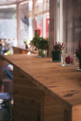 empty wooden bar counter with flowerpots in cafe. table in restaurant