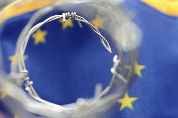 European Union flag and barbed wire, migration to European Union concept