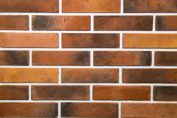 The background is made of artificial stone of black and brown color and has a rectangular shape in the form of a wall made of burnt bricks. Backgrounds, textures, and design.