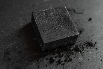 Black carbon charcoal soap on a black granit background 