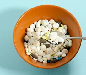 Medication with a spoon. Plate with medicines on a blue background.