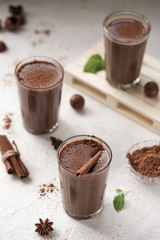 A delicious, natural cocoa drink with grated chocolate and milk in a glass mug is a source of vitamins and energy.