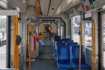Interior view of a corridor inside passenger trains with blue fabric seats of German railway train system. Empty vacant passenger car inside the Tram.
