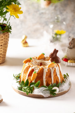 Easter lemon cake with icing and easter decoration. Easter gugelhupf cake with marzipan carrots and chocolate easter bunny
