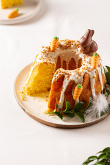 Easter lemon cake with icing and easter decoration. Easter gugelhupf cake with marzipan carrots and chocolate easter bunny