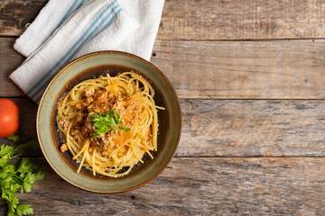 Spaghetti bolognese with parmesan cheese on wooden background