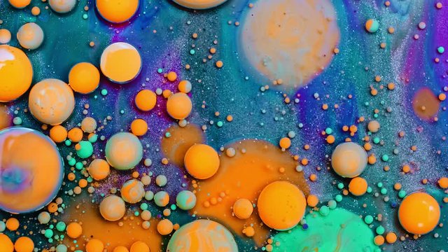 Bubble liquid floats in a paint. Mixing of paint, oil and milk. Gorgeous colorful and bright background, cosmetic effect. Abstract colorful paint and slow motion.