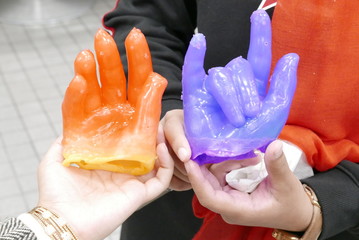 hands holding hollow wax hand sculpture at party event