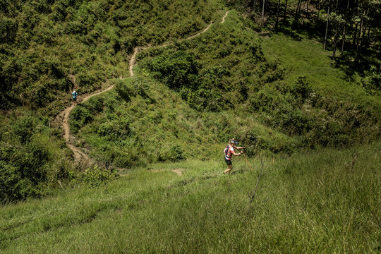 Imagem de vale montanhoso, mostrando as trilhas por onde atletas de trail run sobem, até o topo. Em São Bento do Sapucaí, SP, Brasil.
