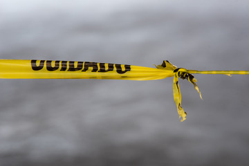 Yellow caution tape with the Spanish word cuidado  stretches across the image