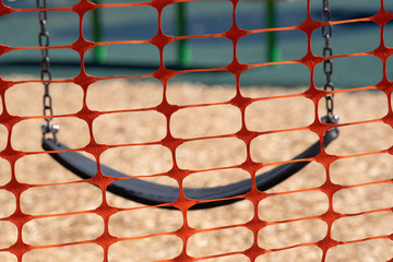 Playground temporarily fenced off due to Covid-19 social distancing restrictions. Children's swing...