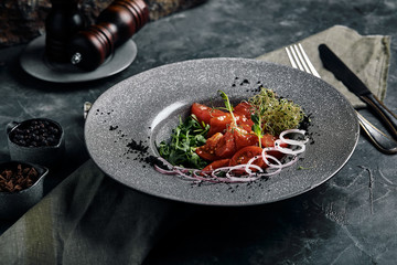 Tuna tagliata in vegetables stewed carrots and peppers, Beautiful serving, traditional Italian cuisine, gray background, copy space. food concept
