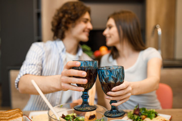 Romantic evening, couple at home kitchen with wine glasses