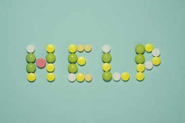 Multi colored tablets laid out the word HELP
