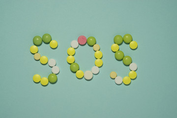 Multi colored tablets laid out the word SOS