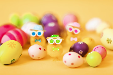 Easter chick and painted Easter eggs isolated on yellow background