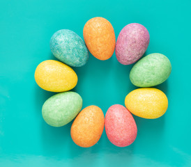 Colourful and bright Easter eggs in a circle shape on blue background