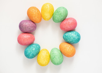Colourful and glittery easter eggs in a circle shape on white background