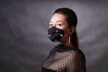 Woman in a black protective mask with rhinestones. Pandemic virus COVID-19