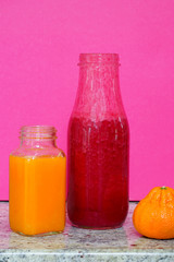 Glass bottles filled with colorful homemade beet smoothies