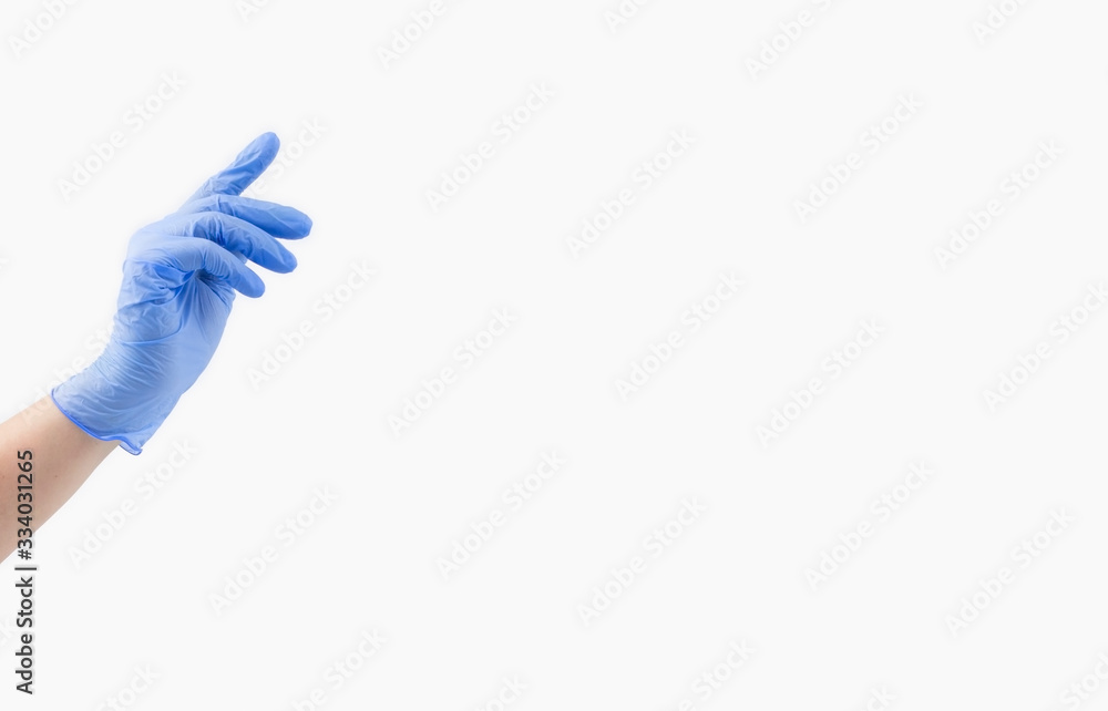 Wall mural One hand of a woman doctor in a blue sterile medical glove on a white background, banner. With your index finger, reach for the top. copy space.