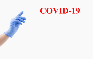 One hand of a woman doctor in a blue sterile medical glove on a white background, banner. With your index finger, reach for the top. copy space. Text Covid-19
