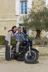 Fototapeta na wymiar Husband shows his wife his new motorcycle