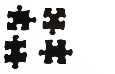 Four black hand-painted pieces of a jigsaw puzzle on white background. Keep separate or distance between each other, group potential concept