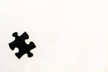 one black hand-painted piece of a jigsaw puzzle on white background. Individual, lonely, one´s potential concept