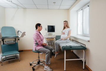 A pregnant girl is advised by a doctor after an ultrasound in the clinic. Medical examination