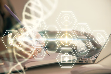 Double exposure of woman hands typing on computer and DNA hologram drawing. Medical education...