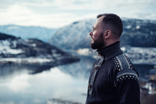 Man looking over Hardangerfjord from house terrace, Norway.