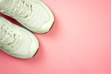 white sneakers on a pink background top view with place for text, the concept of a healthy and active lifestyle, running and sports, taking care of your beautiful body and health