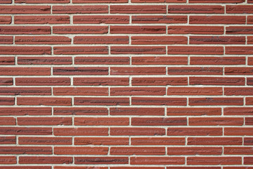 Vintage red color brick wall background with textured striped bricks in a 1/3 offset brickwork pattern