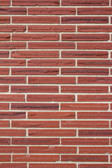 Vintage red color brick wall background with textured striped bricks in a 1/3 offset brickwork pattern
