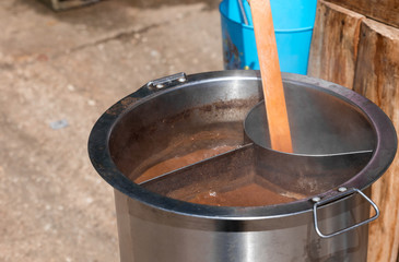 Fototapeta premium Close up view and copy space. Metal pot is boiling noodle soup with steam and stain brown.